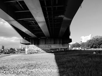 Bridge over field in city against sky