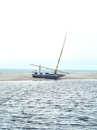 Fishing boat in sea against clear sky