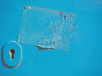 Close-up of keyhole on blue door