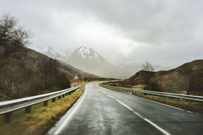 High angle view of vehicles on road by mountain against sky