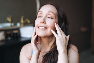 Close up portrait of smiling adult brunette woman in underwear in bathroom at home