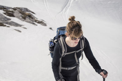 High angle view of young woman snowshoeing on mountain