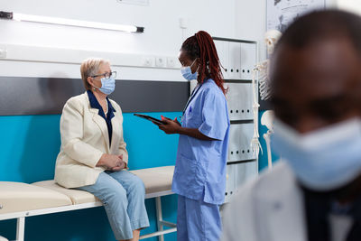 Patient wearing mask examining patient in clinic