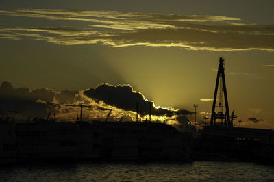 Silhouette sailboats in sea against sky during sunset