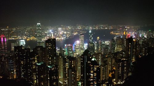 Illuminated cityscape against sky at night