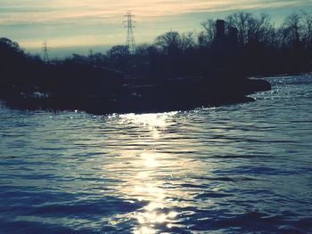 Scenic view of river against sky at sunset