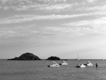 Sailboats in sea against sky