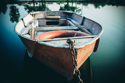 Close-up of abandoned boat moored in water