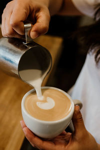 Midsection of woman holding coffee in cafe