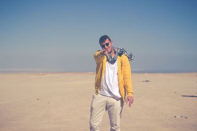 Full length of man standing on beach against clear sky