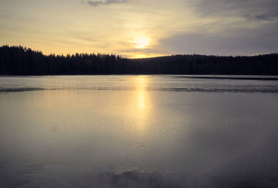 Scenic view of frozen lake against sky during sunset