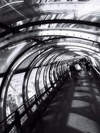 Rear view of people walking in tunnel