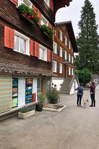 Rear view of people on house against building