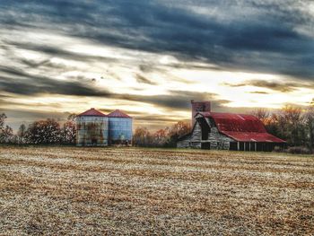 Barn on field against sky during sunset