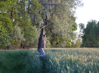 Side view of man jumping on grassy field