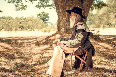 Full length of senior man sitting on field