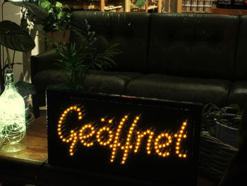 Close-up of illuminated text on sofa at home