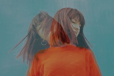 Double exposure image of woman tossing hair