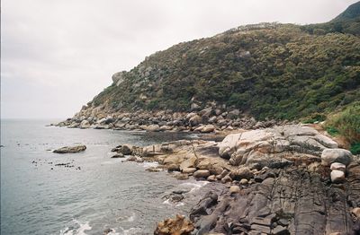 Scenic view of sea and mountains against sky