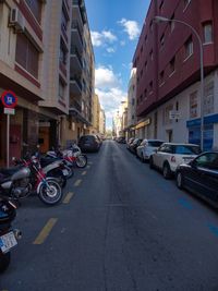 Cars parked on road by buildings in city