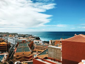 High angle view of townscape by sea against sky