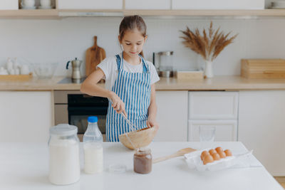 Girl preparing food on kitchen island at home