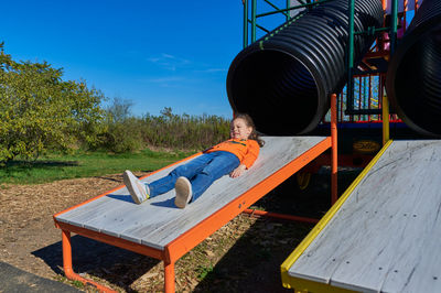 Funny girl sliding down the slide at the farm fair on halloween