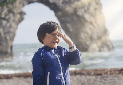 Cute smiling boy standing on beach