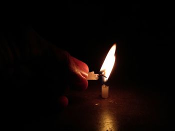 Close-up of hand holding burning candle