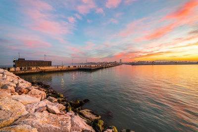 Scenic view of bay against sky during sunset