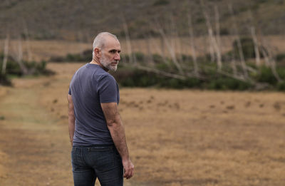 Adult man in jeans standing on field. cabo de gata nature park, almeria, spain