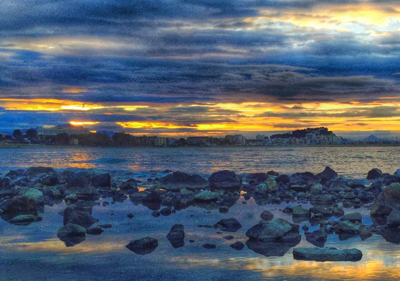 sunset, sky, water, cloud - sky, scenics, tranquil scene, beauty in nature, tranquility, orange color, cloudy, nature, sea, idyllic, rock - object, dramatic sky, cloud, beach, weather, reflection, horizon over water