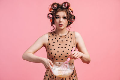 Portrait of a beautiful young woman over pink background