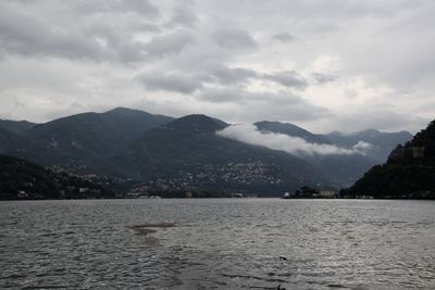 Scenic view of lake by mountains against sky