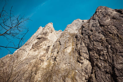 Low angle view of rock formation against clear blue sky