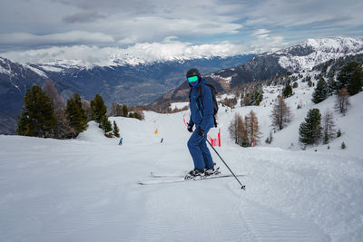 Full length of man skiing on snowcapped mountain against sky