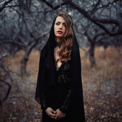 Beautiful young woman standing in forest