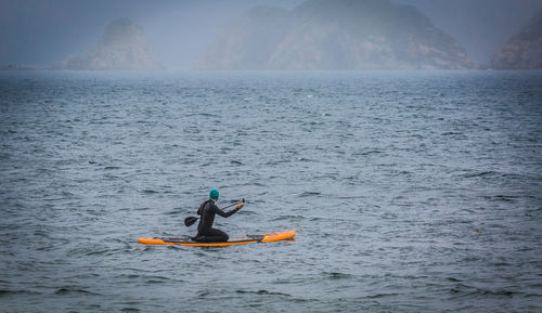 Man paddleboarding in sea