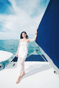 Young woman standing on sea against sky