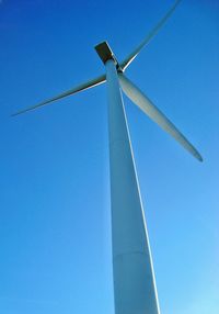 Low angle view of windmill against blue sky