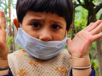 Close-up portrait of girl wearing mask standing outdoors