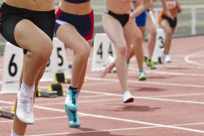 Low section of female athlete sprinting