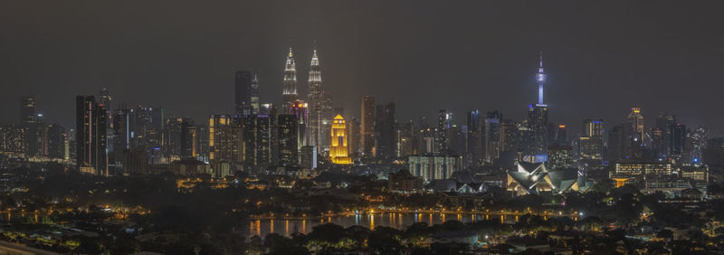 Illuminated cityscape against sky at night