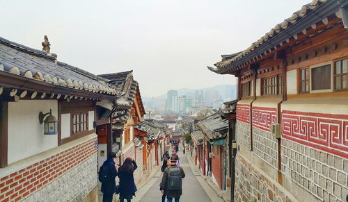 People walking on road along built structures