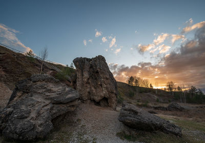 Rock formations on landscape against sky during sunset