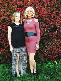 Portrait of smiling female friends standing against plants