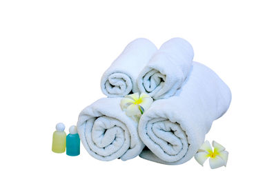 Close-up of white rolled up towels against blue background