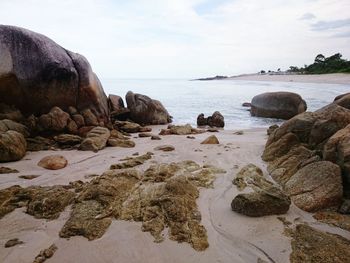 Rocks on beach against sky