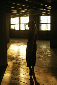 Full length rear view of woman standing in building