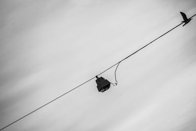 Low angle view of overhead cable car against sky